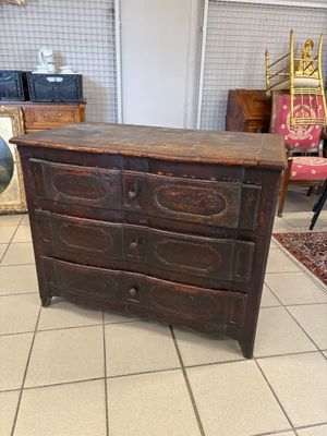 a wooden chest of drawers in a room with a rug
