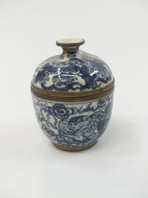 a blue and white bowl with a lid on a white surface
