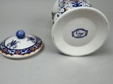 a blue and white cup sitting next to a blue and white container