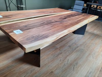 a wooden table with a metal base on a hard wood floor