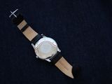 a watch that is laying on a black surface
