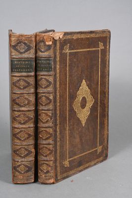 an old book sitting on top of a table next to another book