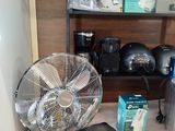 a fan that is sitting on a table next to a toaster and a toaster