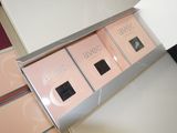 three boxes of makeup on a table in a room