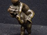 bronze statue of a man holding a dog on a black background