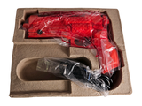a red plastic gun in a cardboard box on a white background