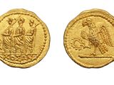 a gold coin with an image of a woman and a bird on it