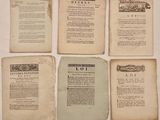 Quatre pages tirées de vieux livres sont posées sur une table, sur fond blanc.