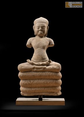 une statue de Bouddha assis au sommet d'un tas de pierres