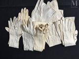 several pairs of white leather gloves on a black surface