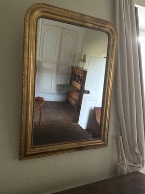 a mirror hanging on the wall next to a dresser