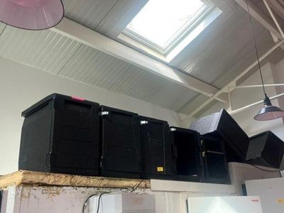 several speakers on top of a shelf in a room