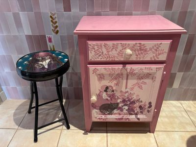 une petite table avec un tiroir, à côté d'un tabouret