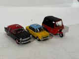 three toy cars sitting next to each other on a white surface