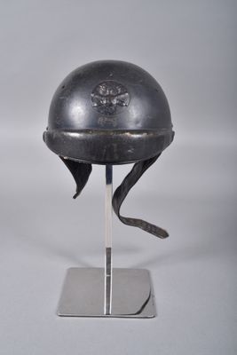 un casque orné d'un crâne, posé sur un socle