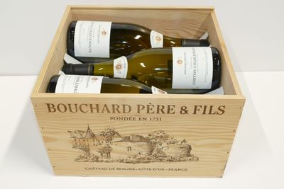 trois bouteilles de vin dans un coffret en bois sur une table