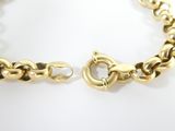 a close up of a gold chain bracelet on a white surface