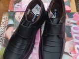 une paire de chaussures en cuir noir pour homme posée sur un magazine