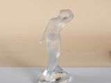 sculpture of a woman standing on a base on a table