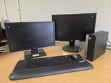 a computer desk with two monitors, a keyboard, and a mouse