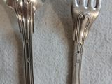 deux cuillères et une fourchette en argent sur une table