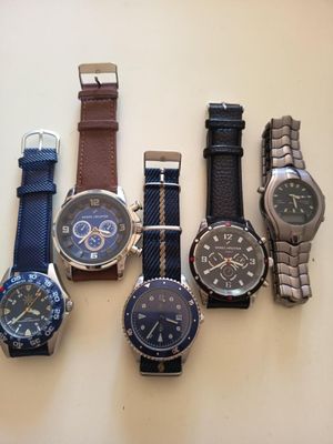 Plusieurs montres différentes sont alignées sur une table