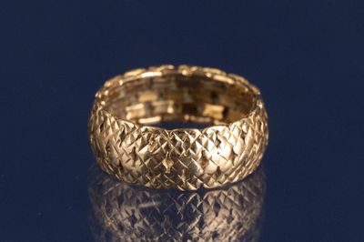 un gros plan d'une bague en or sur une surface bleue