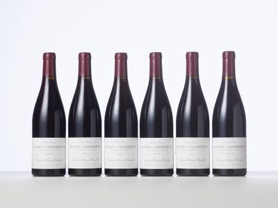 six bottles of red wine lined up in a row