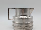 silver plated coffee pot with a handle on a white surface