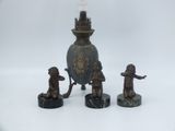 trois figurines de singes et une lampe posées sur une table