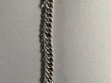 a close up of a silver chain bracelet with a clasp