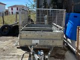 une petite remorque équipée d'une cage à l'arrière