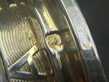 a close up of a silver watch with a diamond in the center