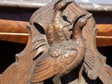 une horloge en bois avec un oiseau sur le cadran