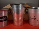 three metal buckets sitting next to each other on a table