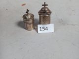 deux petits objets en argent posés sur une table, accompagnés d'une étiquette de prix