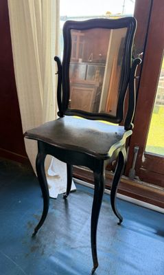 a chair with a mirror on it in front of a window