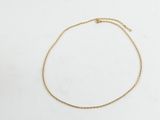 un bracelet-chaîne en or à porter à la cheville, orné d'un petit cœur
