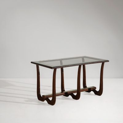 une table basse en verre et en bois, avec des pieds courbés et un plateau en verre