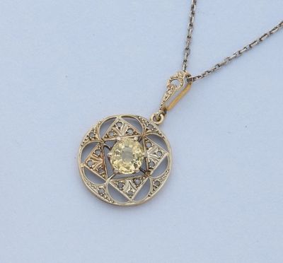 un gros plan d'un pendentif en diamant jaune monté sur une chaîne