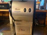 a coffee maker sitting on a counter in a restaurant