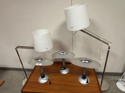 trois lampes posées sur une table, sur laquelle se trouve une autre lampe