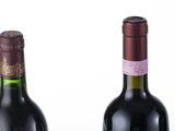 three bottles of wine are lined up in a row on a white surface