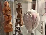 a glass display case with a variety of vases and figurines on it