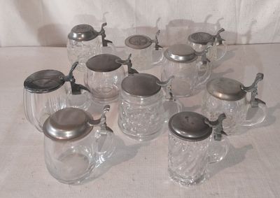 de nombreux bocaux en verre avec leurs couvercles et des cuillères posés sur une table
