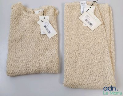 two bags with tags on them sitting on a white surface