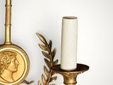 an image of a gold candle holder with a coin on top of it
