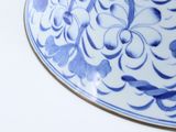 a blue and white plate on a white table
