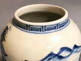 a blue and white vase with a mountain scene on it