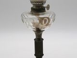 une lampe à huile à l'ancienne, surmontée d'un abat-jour en verre